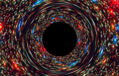 超大質量ブラックホールのコンピュータシミュレーション画像。暗い部分は事象の地変線で周囲の星の光は重力で歪んでいる。