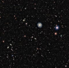 ダークエネルギーカメラが撮影した広域の天体画像。ここには大量の銀河が映っており、もっとも大きく見えているのが「渦巻銀河ESO440-11」。