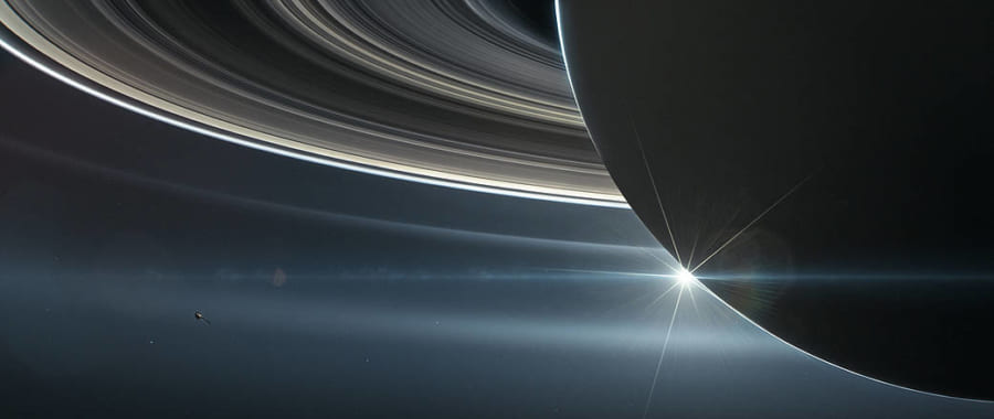 土星のリングとカッシーニのイラスト。よく見ると左下に小さく画かれたカッシーニが見える。
