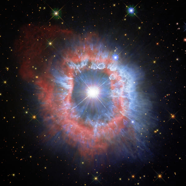 これまでの観測画像を合わせた「りゅうこつ座AG星」の画像。赤はイオン化したガス。青は塵の残骸を示している。