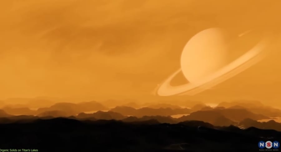 土星の周りを公転するタイタン。その大気はぼんやりとしたオレンジ色になっている