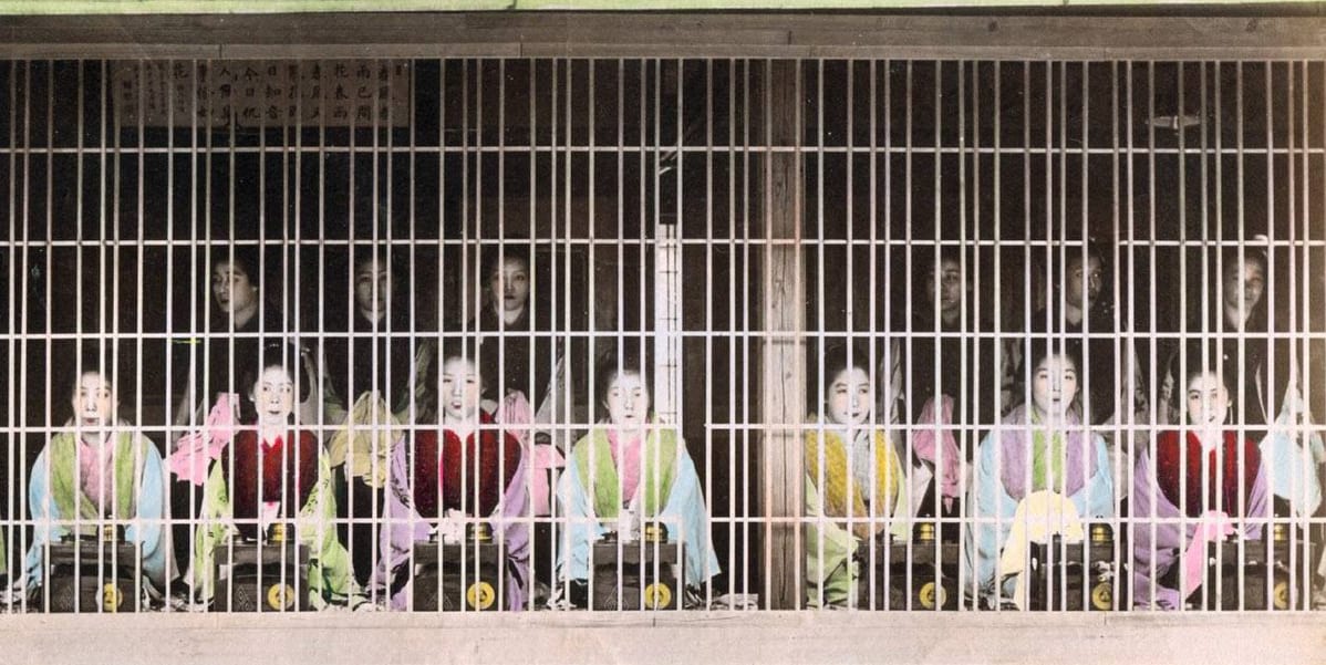 吉原の遊女、このように遊女たちは格子窓の部屋に並んで三味線を弾いていた